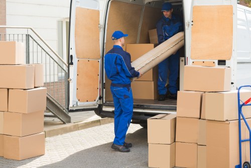 Removal company pricing discussion with moving boxes and furniture in Roehampton