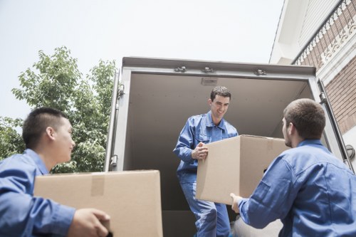 Local movers preparing furniture for transport in a Roehampton home